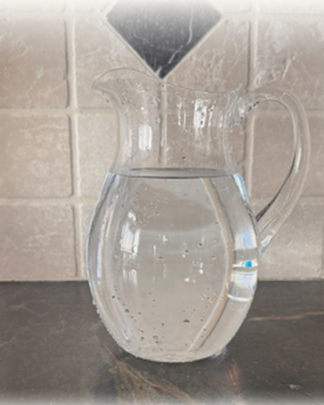Tap water in a glass pitcher, clear