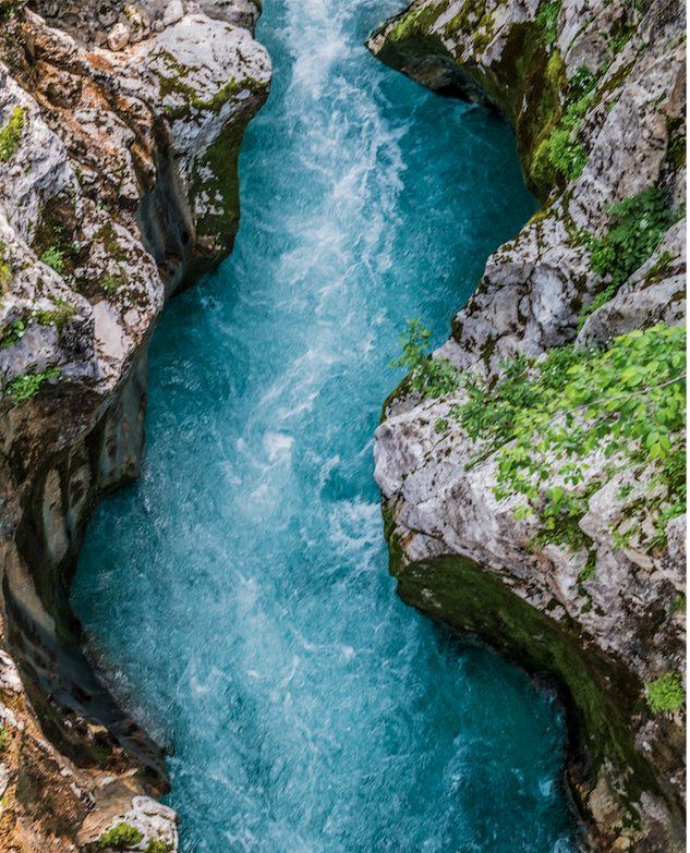 A river running turquoise through a narrow limestone gorge